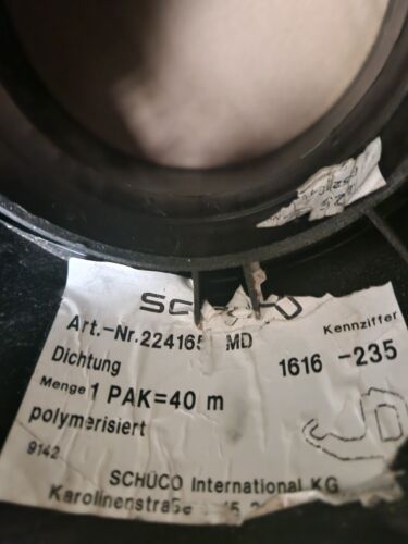 A close-up of a SCHÜCO branded glazing gasket packaging with visible text indicating the product is a rubber wedge gasket for aluminium windows, 10 meters in length.