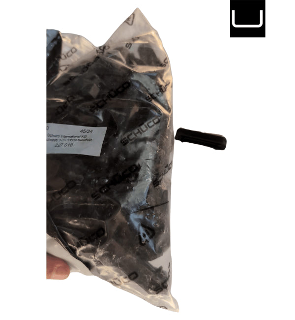 Clear plastic bag with black components inside, held by a hand on a white background.