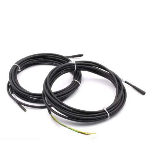 Two coiled black cables with green wires on a white background